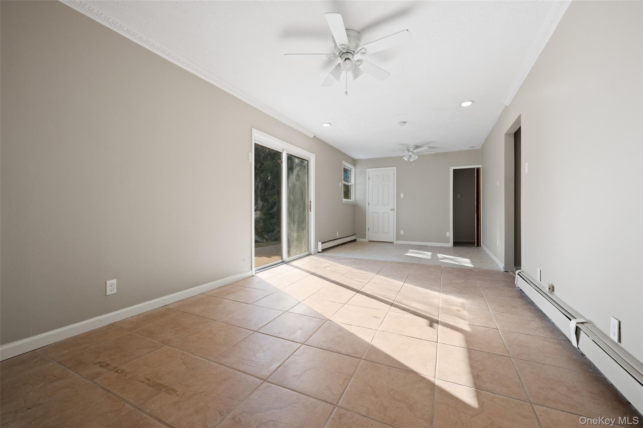 40 Duke Street Deer Park, NY 11729 - Photo 15 of 15 Unfurnished room with recessed lighting, light tile patterned floors, a ceiling fan, a baseboard heating unit, and ornamental molding