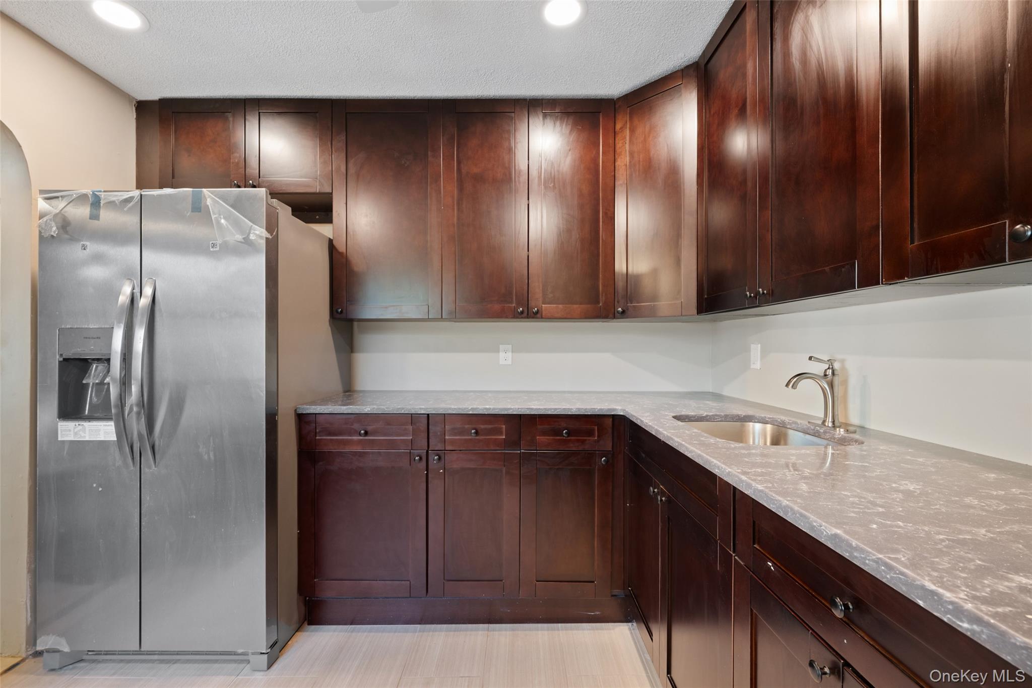 40 Duke Street Deer Park, NY 11729 - Photo 5 of 15 Kitchen with light stone counters, stainless steel fridge with ice dispenser, recessed lighting, and dark brown cabinetry