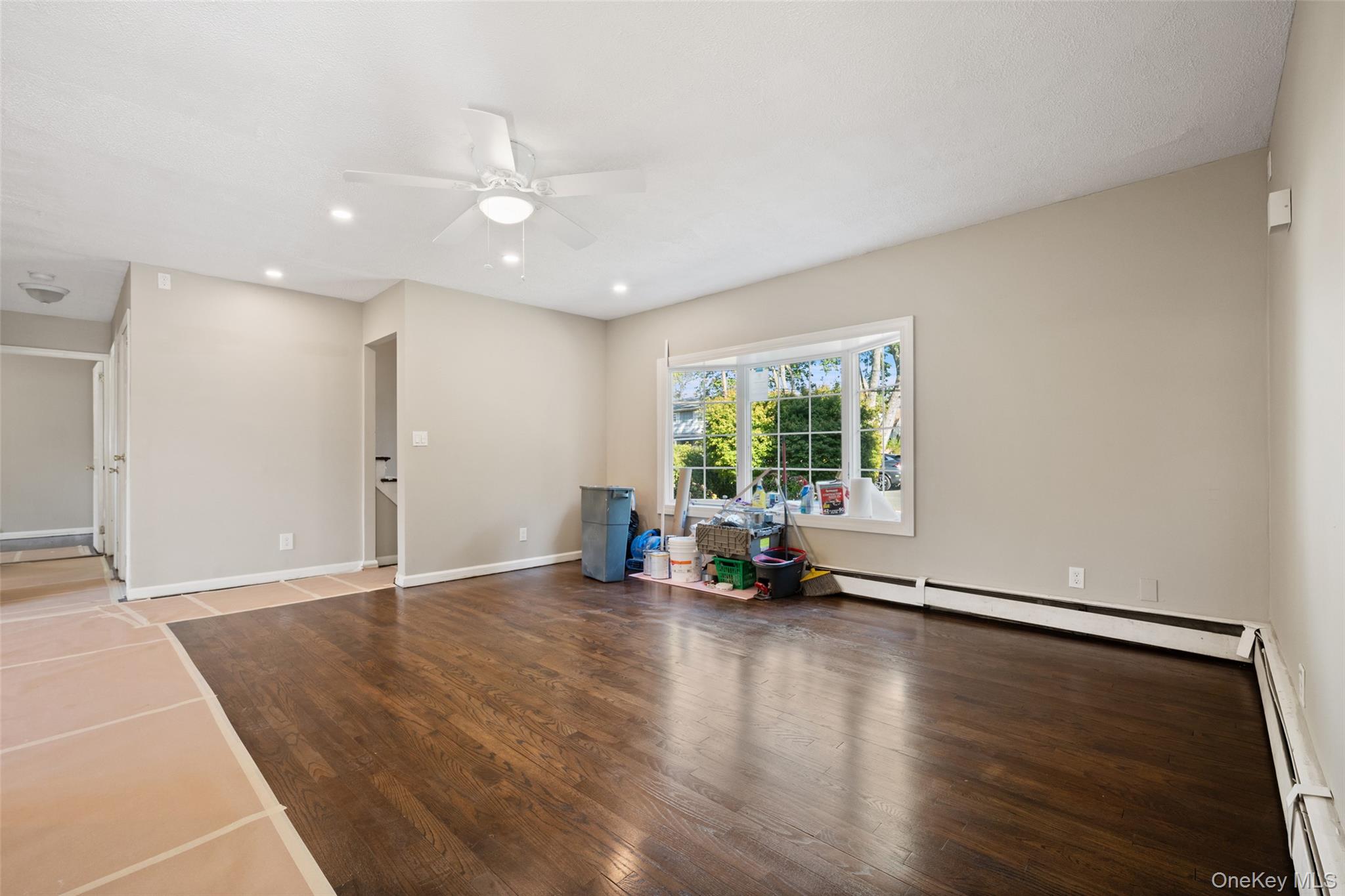 40 Duke Street Deer Park, NY 11729 - Photo 6 of 15 Unfurnished living room featuring wood finished floors, a baseboard heating unit, ceiling fan, and recessed lighting
