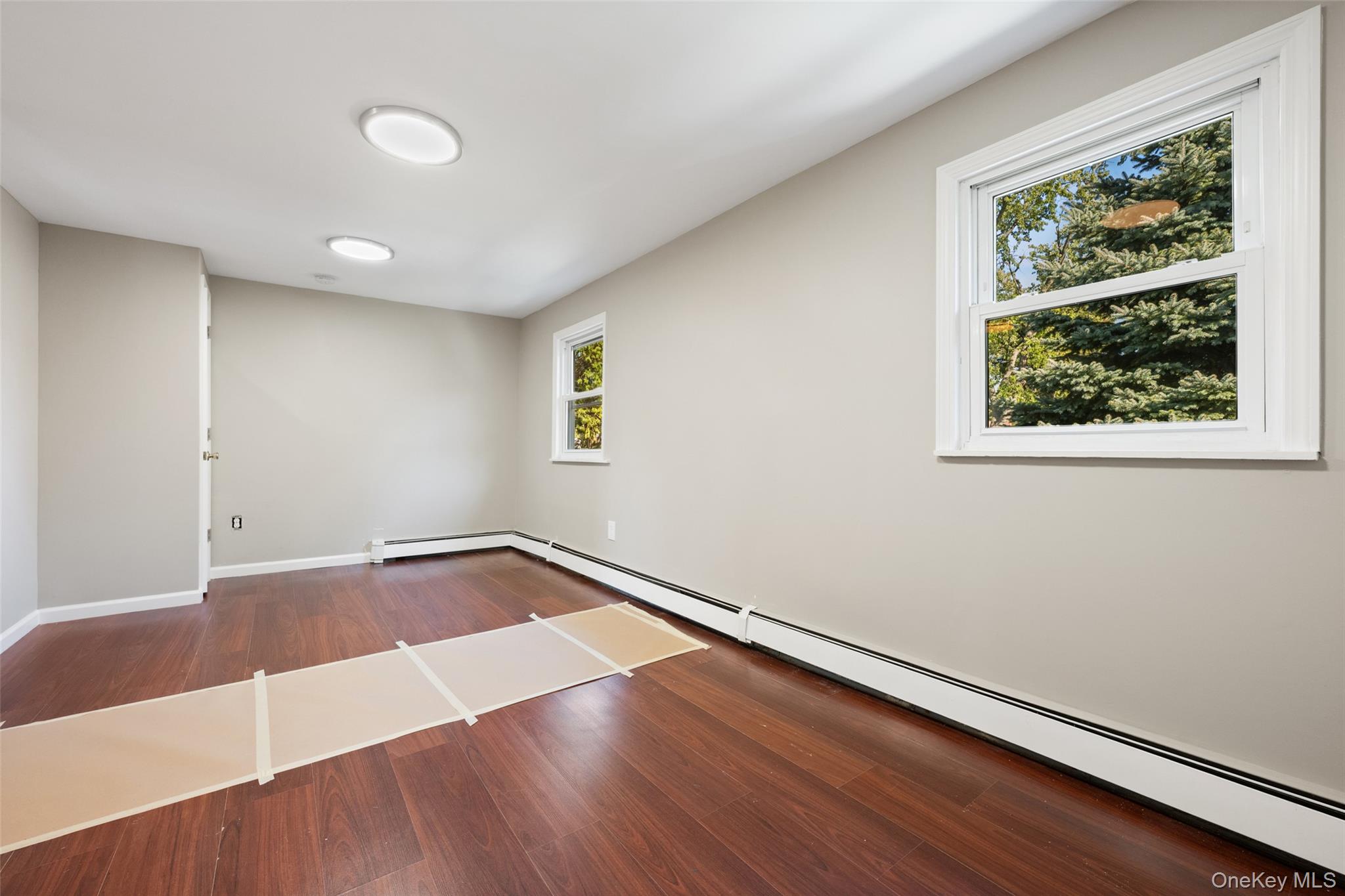 40 Duke Street Deer Park, NY 11729 - Photo 10 of 15 Empty room with dark wood-style flooring and baseboard heating