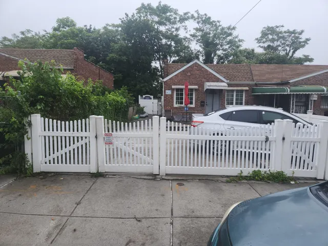 a view of a house with wooden fence