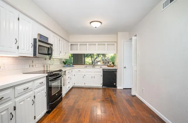 a kitchen with granite countertop white cabinets and white appliances
