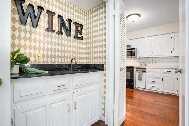 a kitchen with granite countertop white cabinets and white appliances