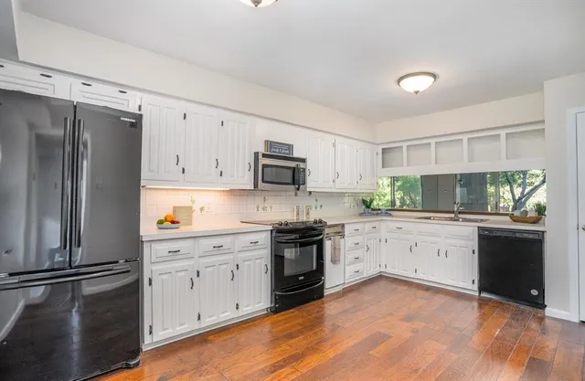 a kitchen with granite countertop white cabinets and white appliances