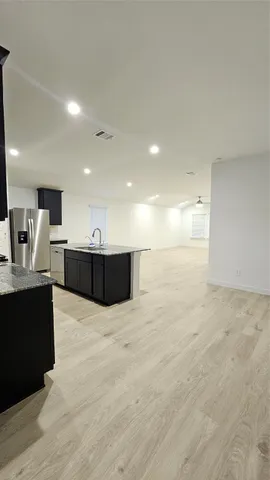 a view of kitchen with kitchen island sink and center island