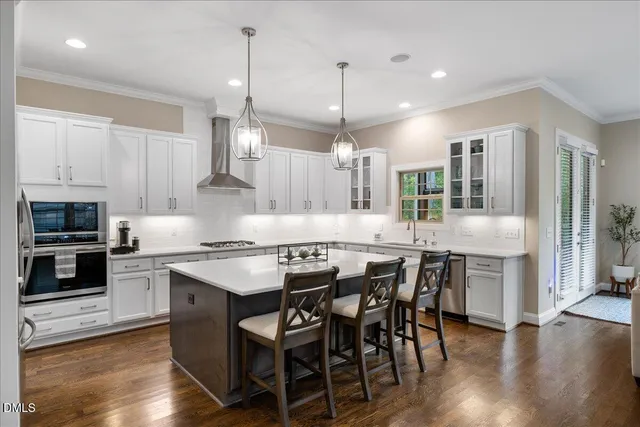 a kitchen with stainless steel appliances a stove a sink island and a refrigerator
