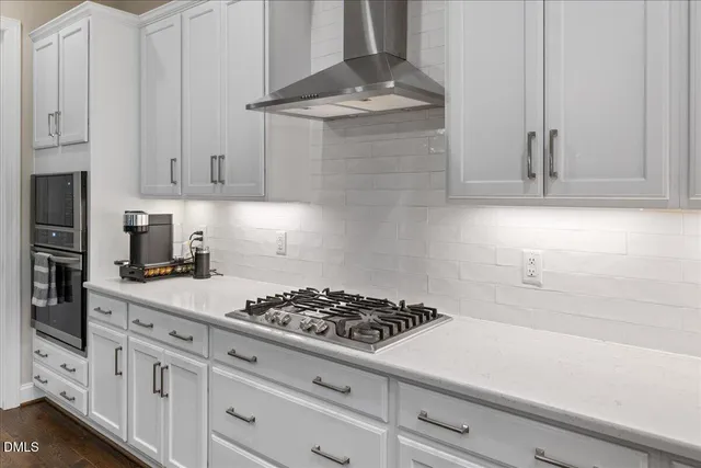 a kitchen with stainless steel appliances sink stove refrigerator and cabinets