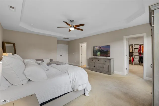 a spacious bedroom with a bed and a chandelier