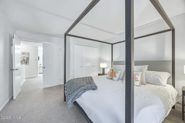 a bedroom with a bed and a large mirror