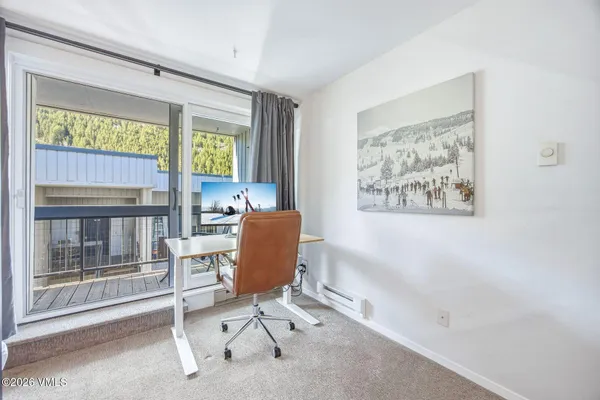 a view of a workspace with furniture and a window