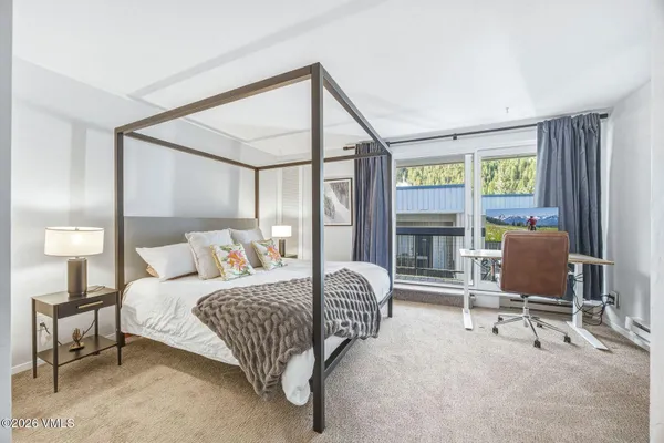 a bedroom with a bed wooden floor and a window