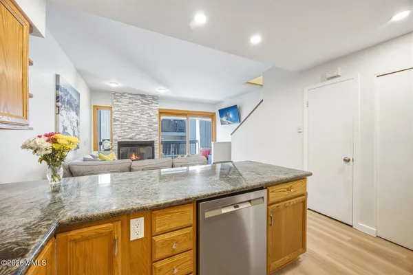 a kitchen with stainless steel appliances granite countertop a sink a counter space and a window