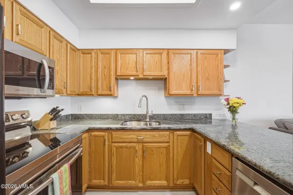 a kitchen with stainless steel appliances granite countertop a sink stove and cabinets