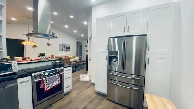 a kitchen with stainless steel appliances granite countertop a refrigerator and a stove