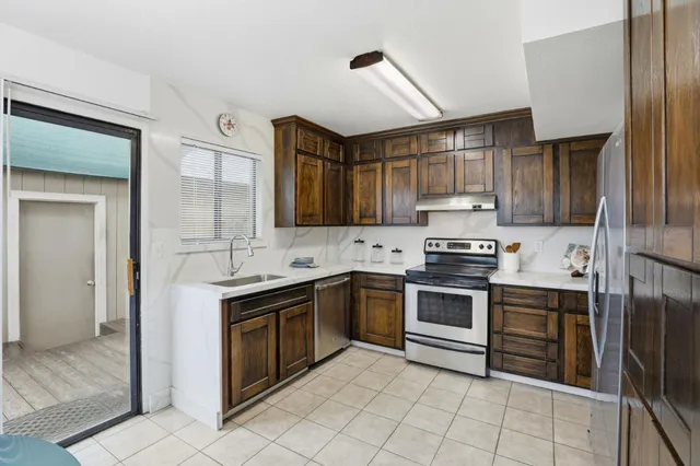 a kitchen with stainless steel appliances granite countertop a refrigerator stove and sink