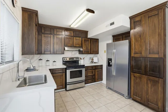 a kitchen with stainless steel appliances wooden cabinets and a stove top oven