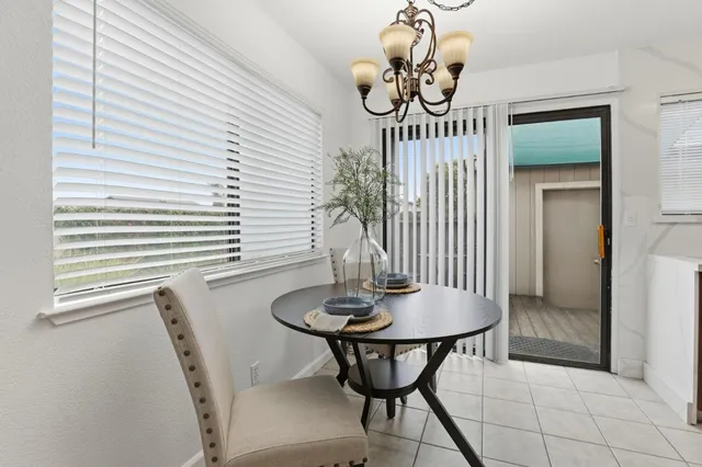 a room with a table chairs and windows