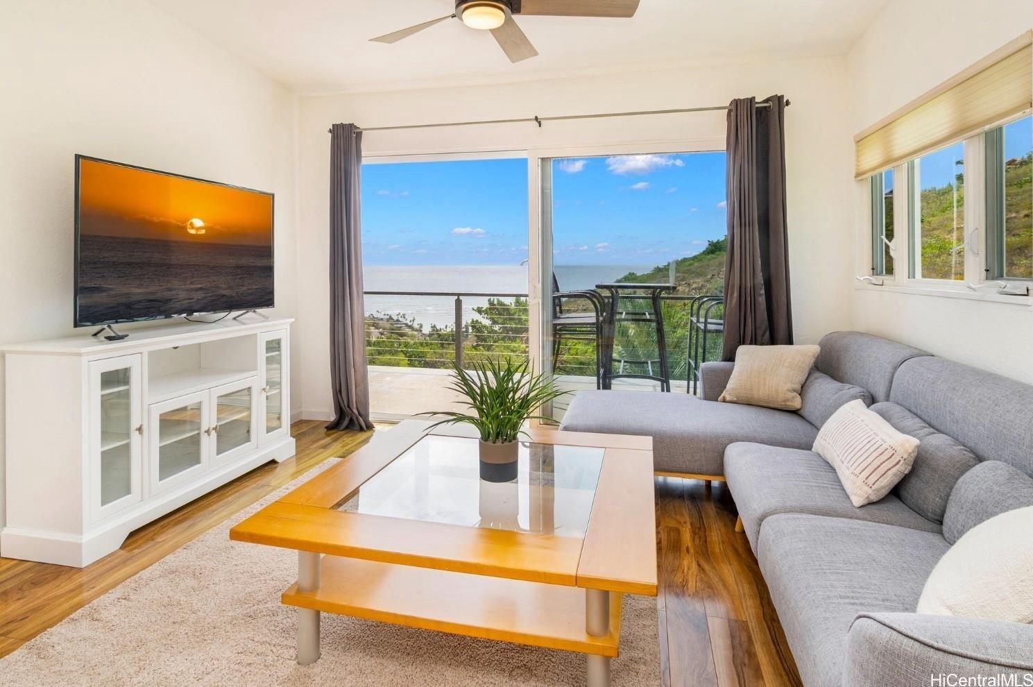 5436 Poola Street Honolulu, HI 96821 - Photo 15 of 21 a living room with furniture a flat screen tv and a floor to ceiling window