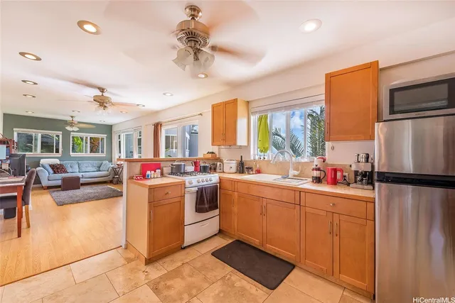 a kitchen that has a lot of cabinets stainless steel appliances and a dining table