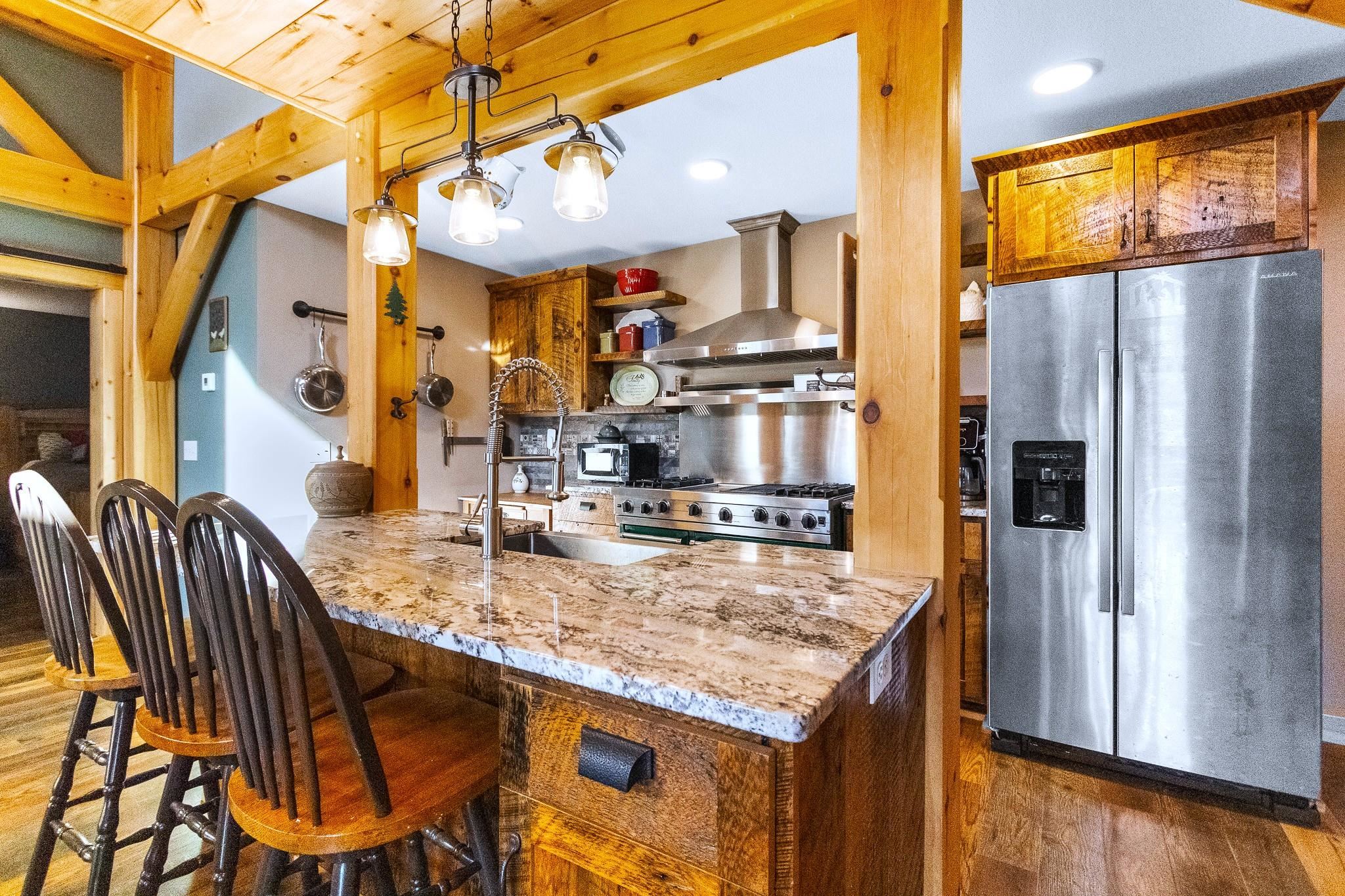 6014 Brown Road Kettle River, MN 55757 - Photo 13 of 54 Kitchen featuring appliances with stainless steel finishes, dark wood finished floors, a kitchen breakfast bar, and pendant lighting