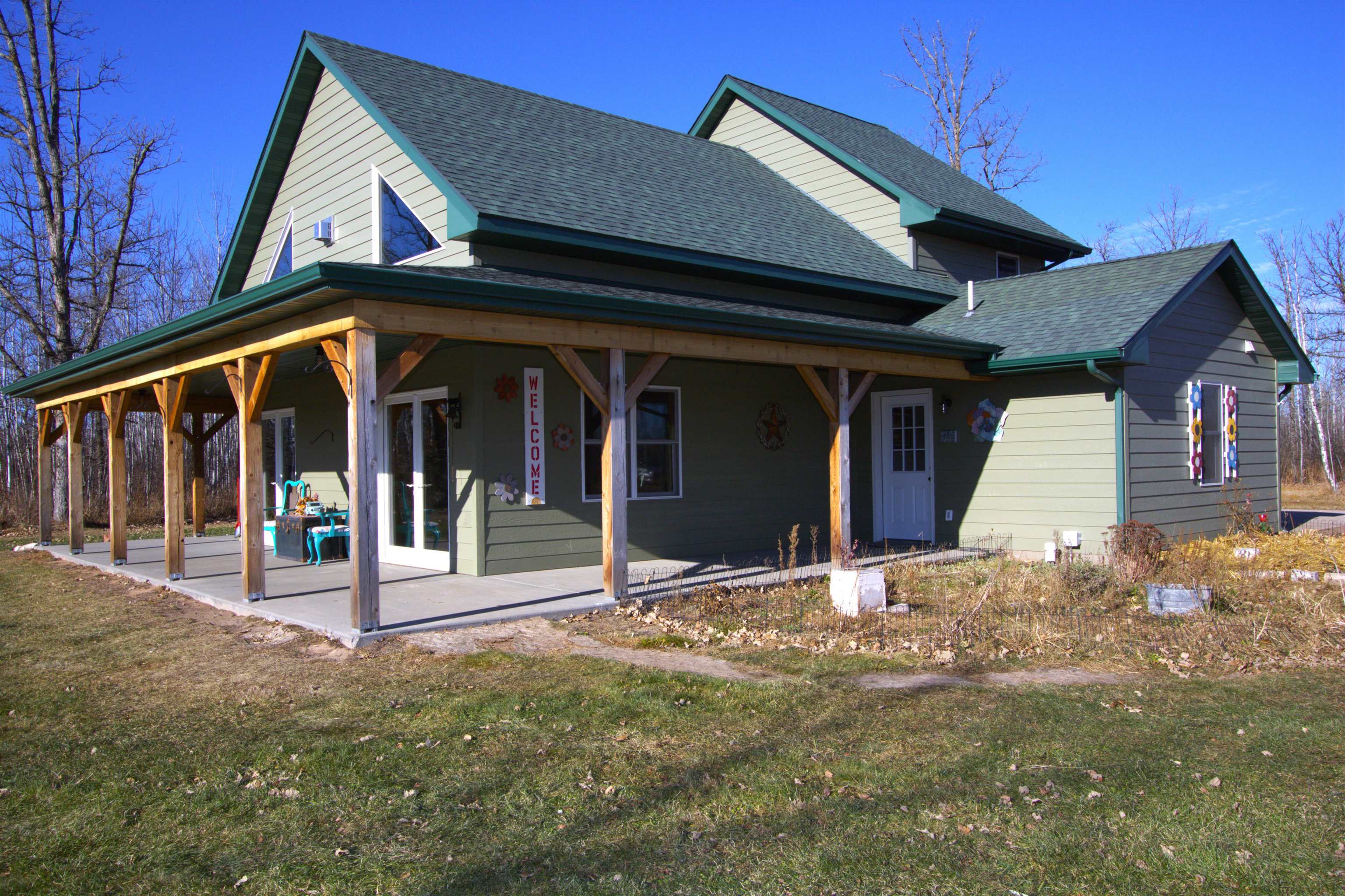 6014 Brown Road Kettle River, MN 55757 - Photo 4 of 54 Rear view of house featuring a shingled roof, covered porch, and a lawn