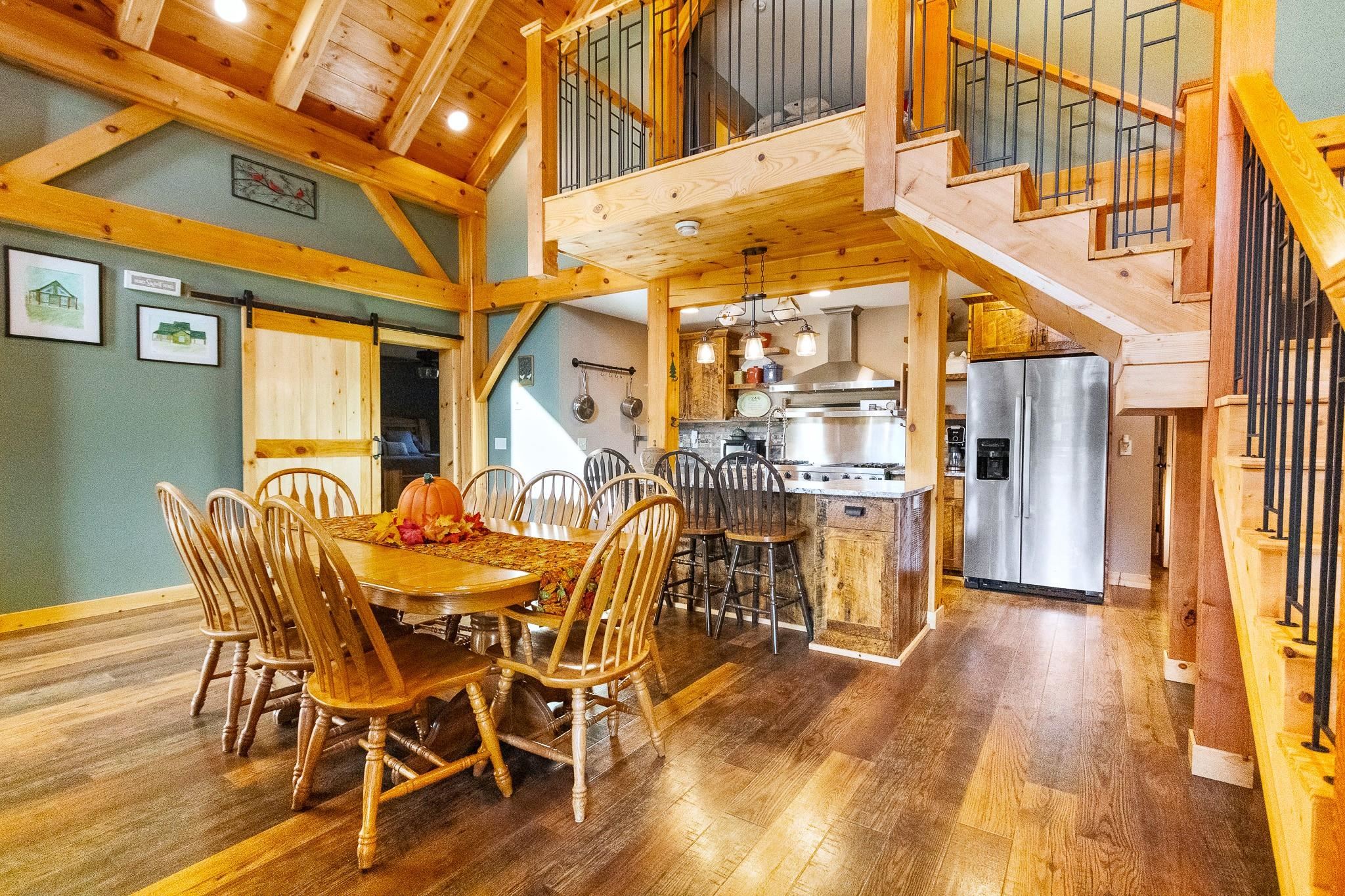 6014 Brown Road Kettle River, MN 55757 - Photo 9 of 54 Dining space featuring stairs, a barn door, wood-type flooring, a wooden ceiling with exposed beams, and high vaulted ceiling