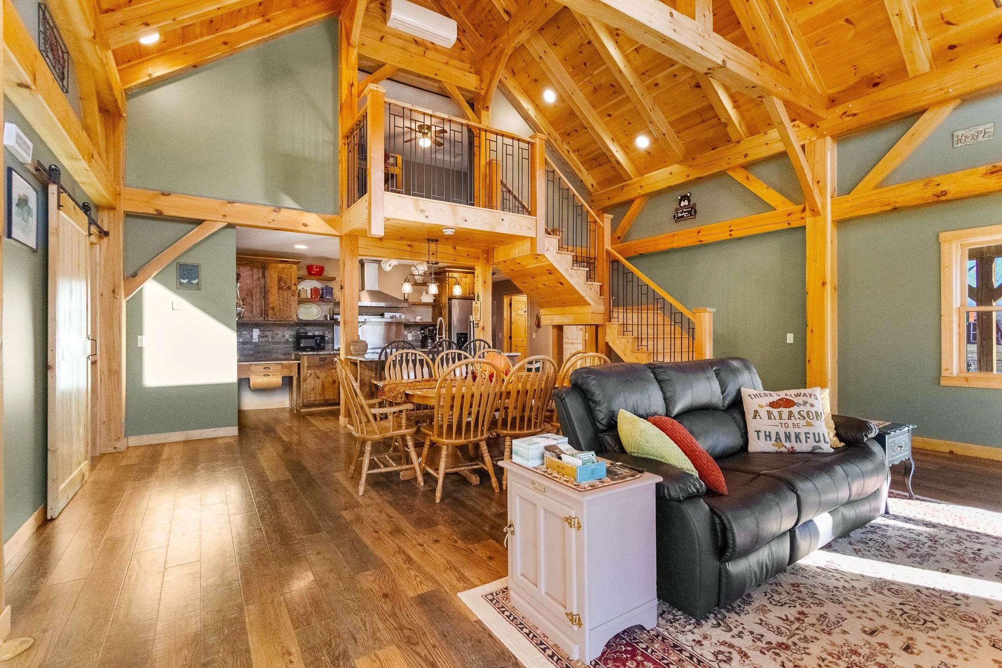 6014 Brown Road Kettle River, MN 55757 - Photo 10 of 54 Living area with stairs, wood-type flooring, a barn door, recessed lighting, and beamed ceiling