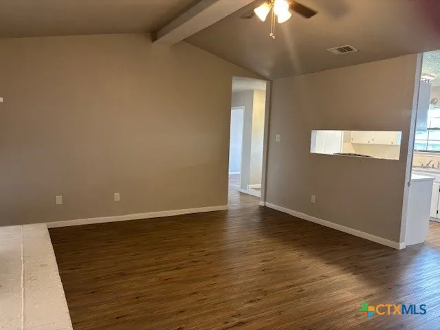 wooden floor in an empty room with a chandelier fan