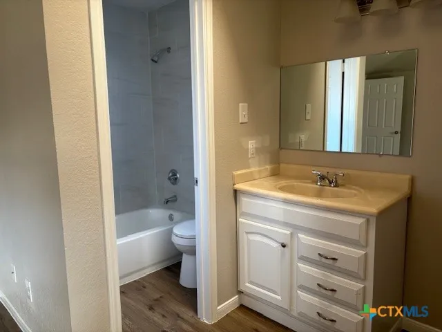 a bathroom with a granite countertop sink a toilet and shower