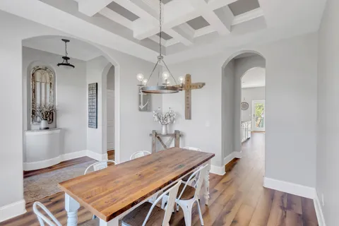 a open kitchen with stainless steel appliances granite countertop a stove a sink dishwasher and a dining table with wooden floor