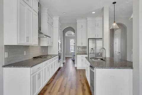 a kitchen with stainless steel appliances granite countertop a stove and a wooden floors