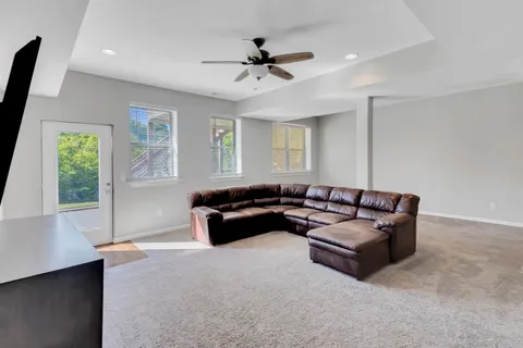 an empty room with windows and ceiling fan