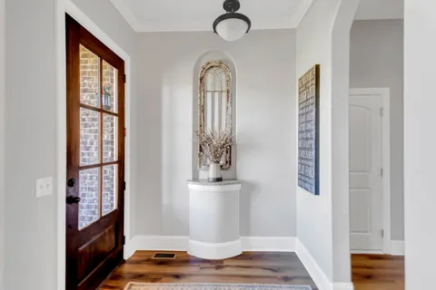 a room with a table chairs and wooden floor