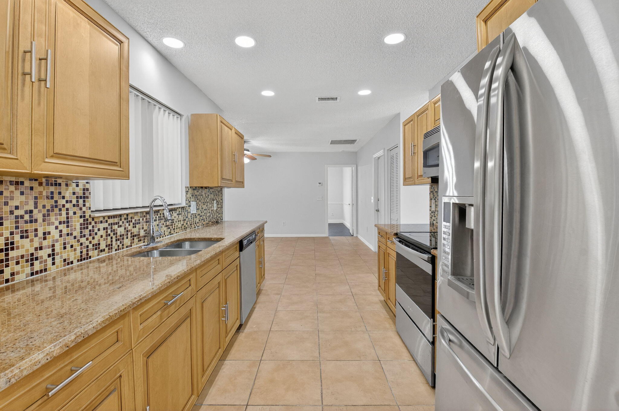 4135 Bay Laurel Way Boca Raton, FL 33487 - Photo 13 of 52 a kitchen with stainless steel appliances granite countertop a stove a sink and a refrigerator