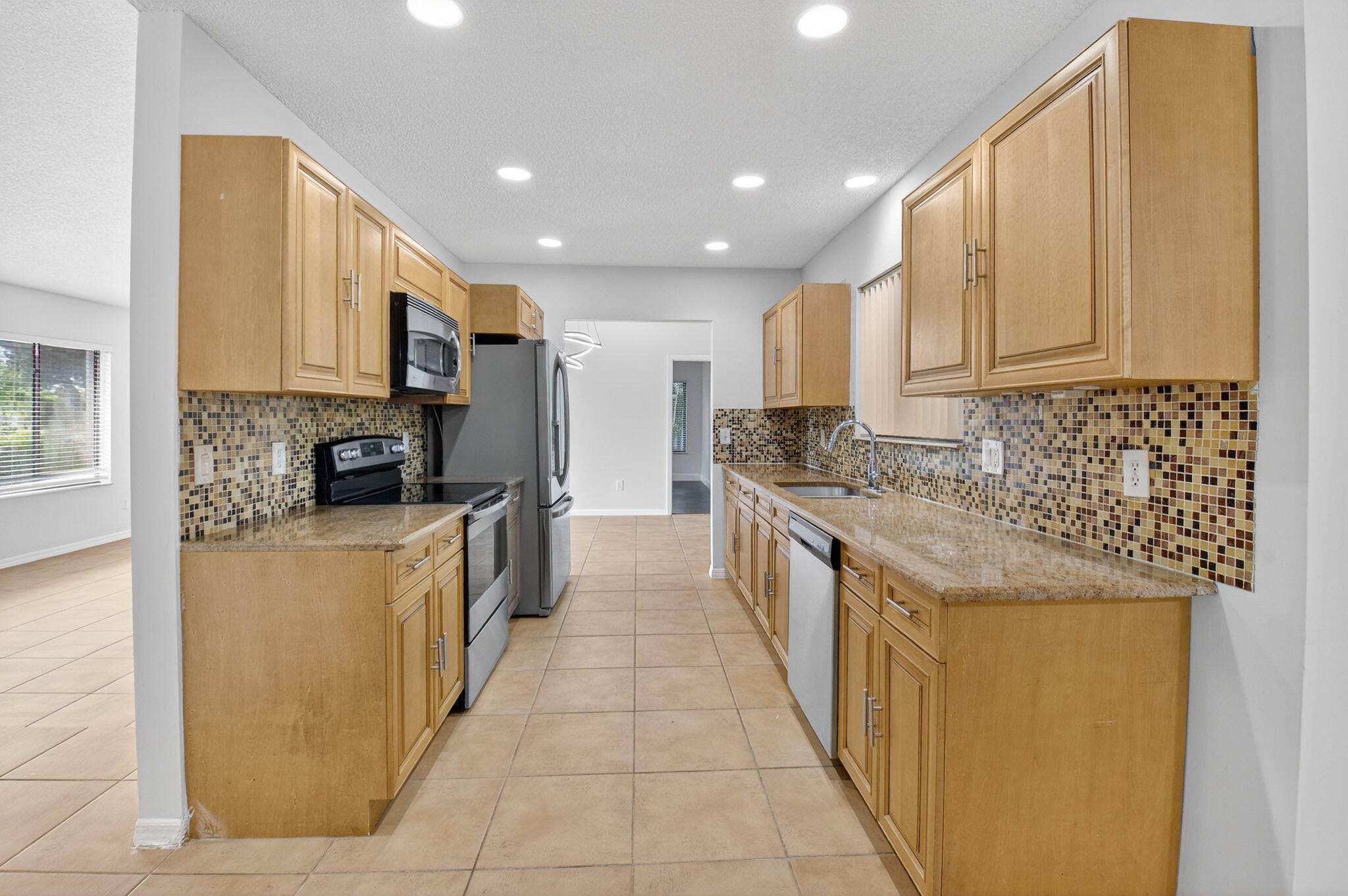 4135 Bay Laurel Way Boca Raton, FL 33487 - Photo 16 of 52 a kitchen with stainless steel appliances granite countertop a stove a sink and a refrigerator