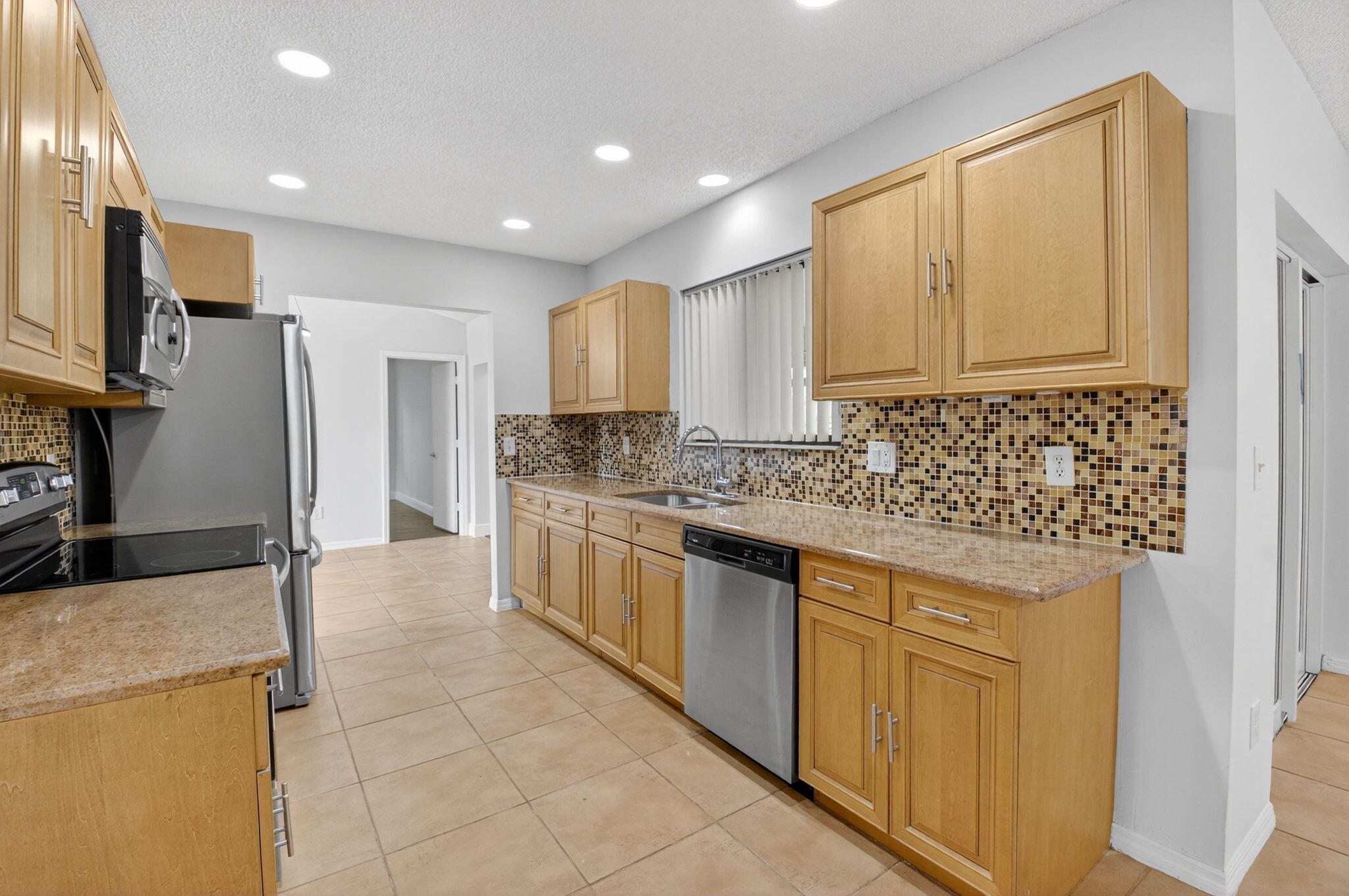 4135 Bay Laurel Way Boca Raton, FL 33487 - Photo 17 of 52 a kitchen with stainless steel appliances granite countertop a refrigerator a stove and a sink