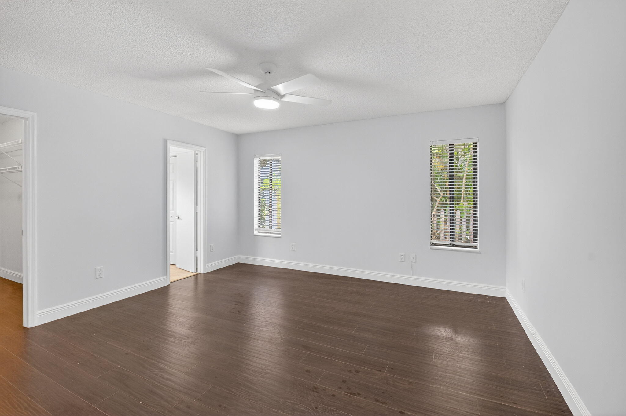4135 Bay Laurel Way Boca Raton, FL 33487 - Photo 23 of 52 an empty room with wooden floor chandelier fan and windows
