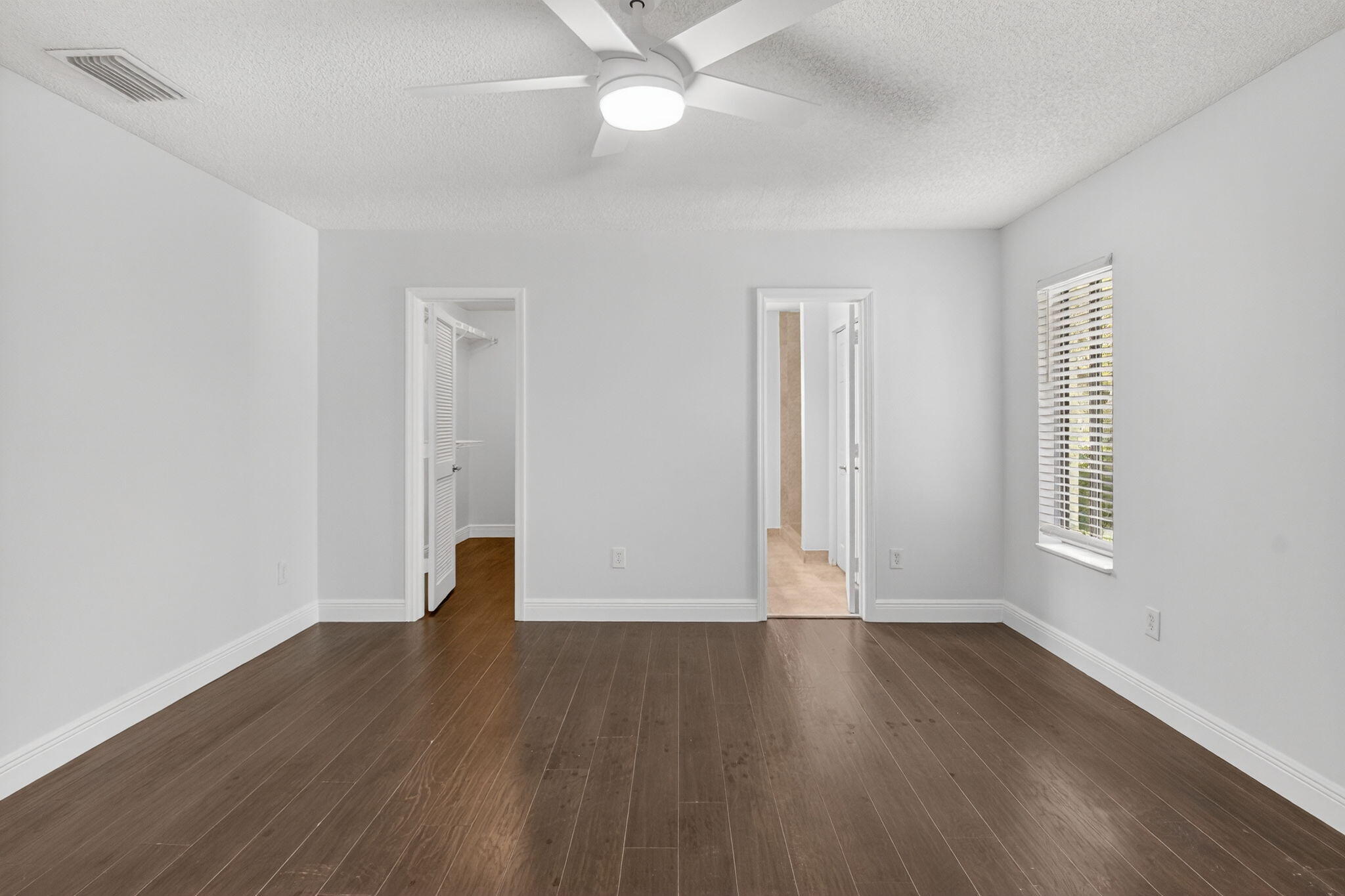 4135 Bay Laurel Way Boca Raton, FL 33487 - Photo 24 of 52 an empty room with wooden floor and windows