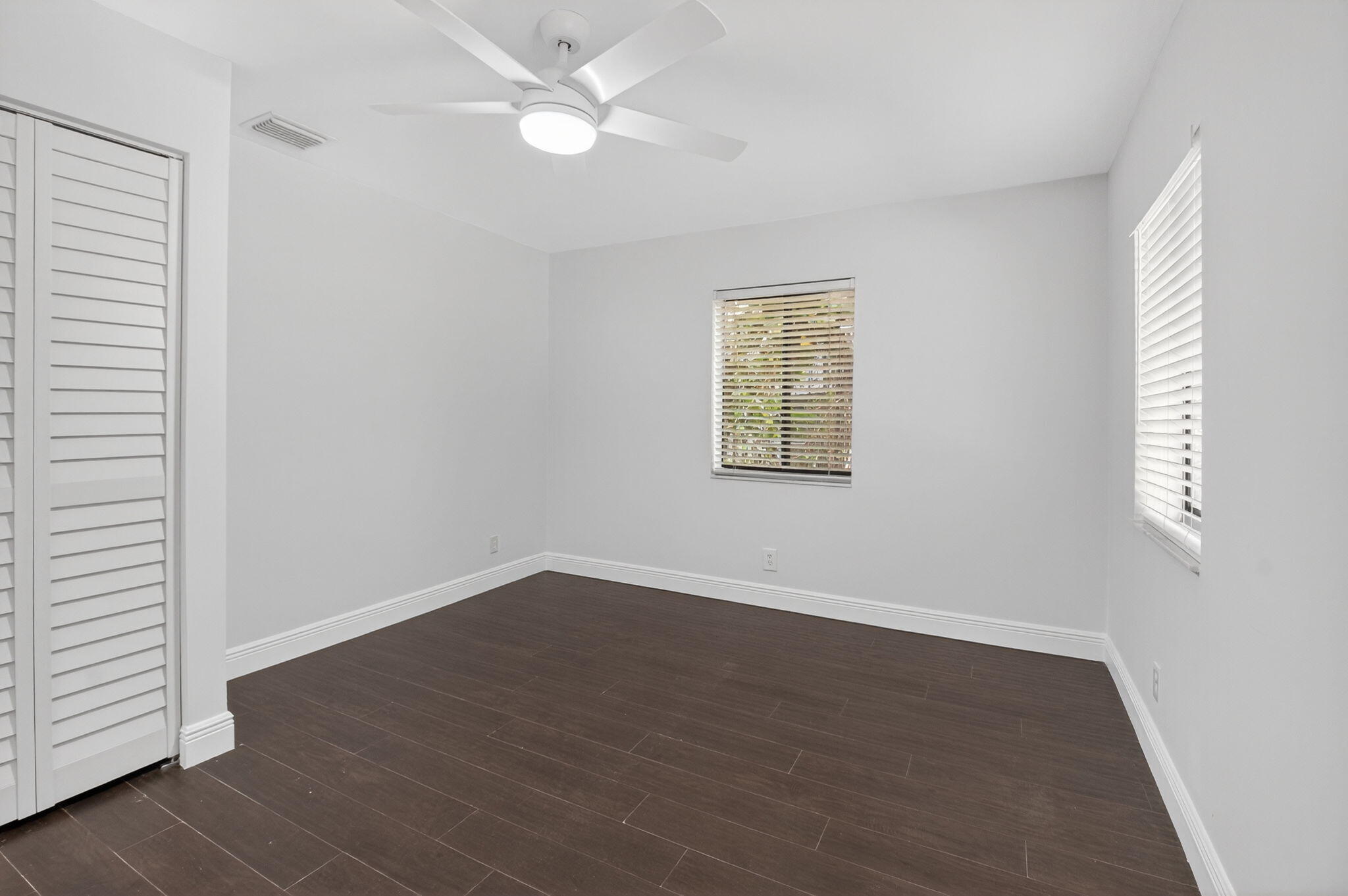 4135 Bay Laurel Way Boca Raton, FL 33487 - Photo 30 of 52 an empty room with wooden floor fan and windows