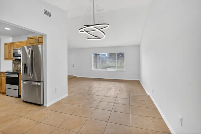 a view of a livingroom with a chandelier fan and windows