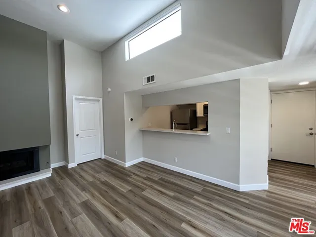 a view of a livingroom with wooden floor and a flat screen tv