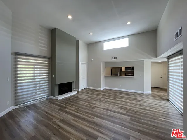 a view of empty room with wooden floor and fireplace