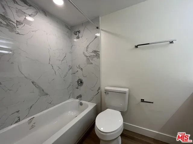 a white toilet and tub sitting next to a bathroom sink