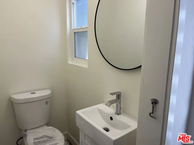 a bathroom with a sink mirror and toilet