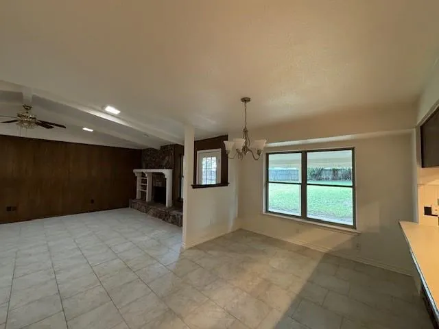 a view of an empty room with a fireplace and cabinet