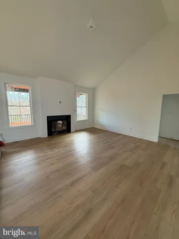 a view of empty room with wooden floor and fireplace