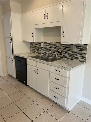 a kitchen with granite countertop white cabinets and black appliances