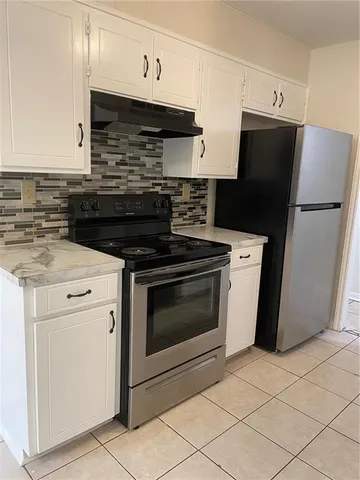 an empty room with a chandelier fan