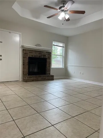 an empty room with kitchen view and fireplace