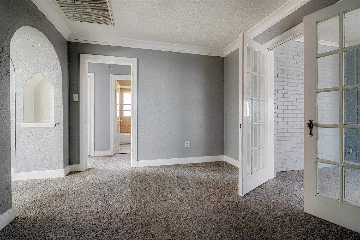 1114 Brownlee Road Memphis, TN 38116 - Photo 21 of 32 Unfurnished room with a textured wall, crown molding, french doors, carpet, and a textured ceiling
